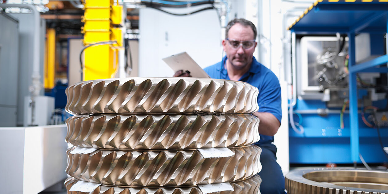 Engineer with bronze cogs in engineering factory Staffing for Manufacturing